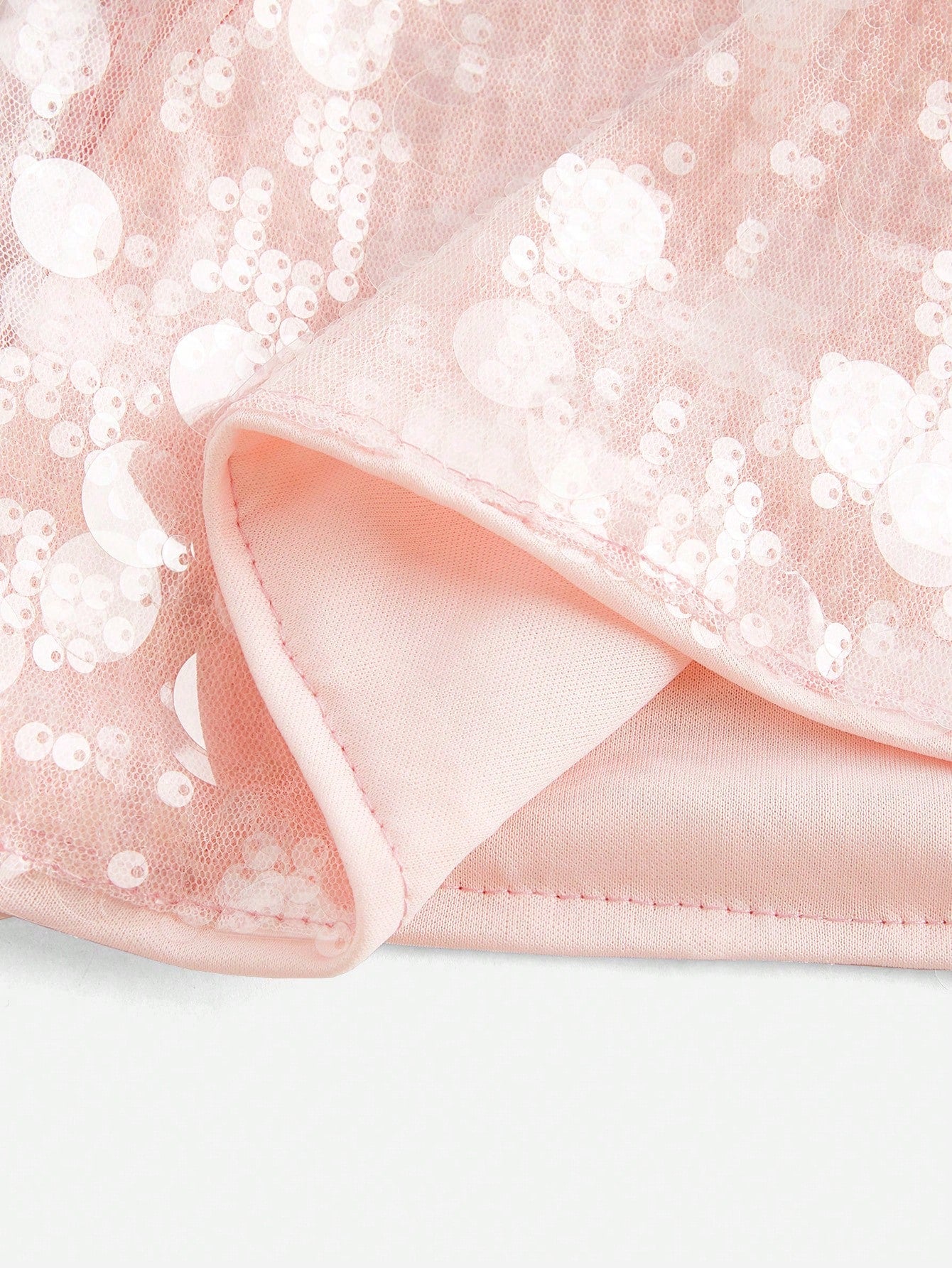 ملابس نسائية أنيقة، تنورة قصيرة وردية مزينة بالترتر. مناسبة للمواعيد، والحفلات