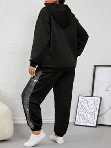 طقم نسائي (قطعتين): هودي مزين بالترتر وبنطلون مخطط بشريط جانبي من كالفايا