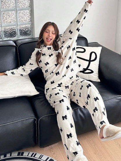 بيجامه بناتي (قطعتين): تيشيرت بأكمام طويلة ورقبة دائرية وبنطلون بنقشة فيونكات من شي إن