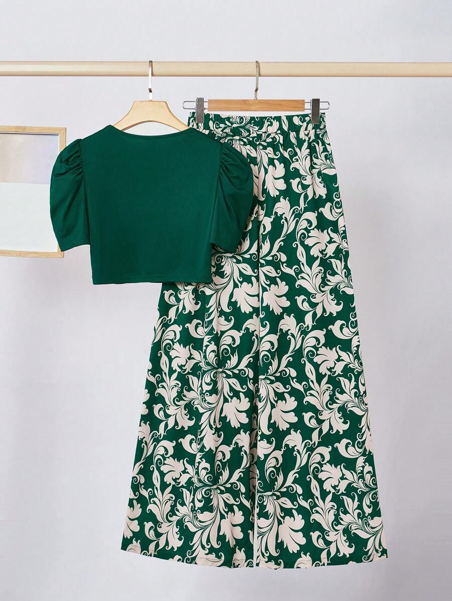 طقم أنثوي أنيق مكون من بلوزة قصيرة باللون الأخضر الغامق وبنطلون واسع بنقشة فخمة