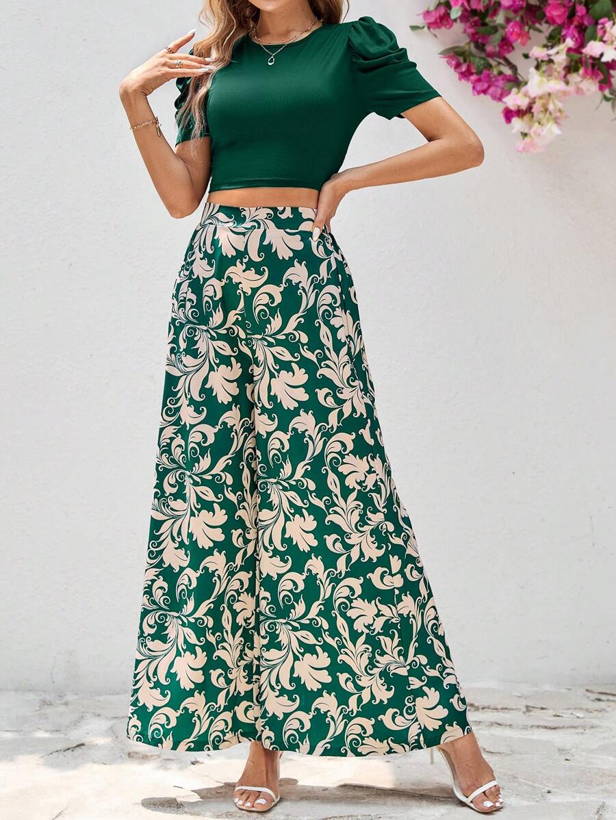 طقم أنثوي أنيق مكون من بلوزة قصيرة باللون الأخضر الغامق وبنطلون واسع بنقشة فخمة