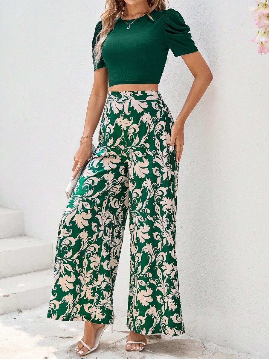 طقم أنثوي أنيق مكون من بلوزة قصيرة باللون الأخضر الغامق وبنطلون واسع بنقشة فخمة
