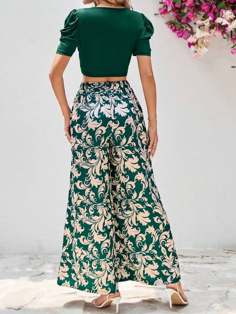 طقم أنثوي أنيق مكون من بلوزة قصيرة باللون الأخضر الغامق وبنطلون واسع بنقشة فخمة