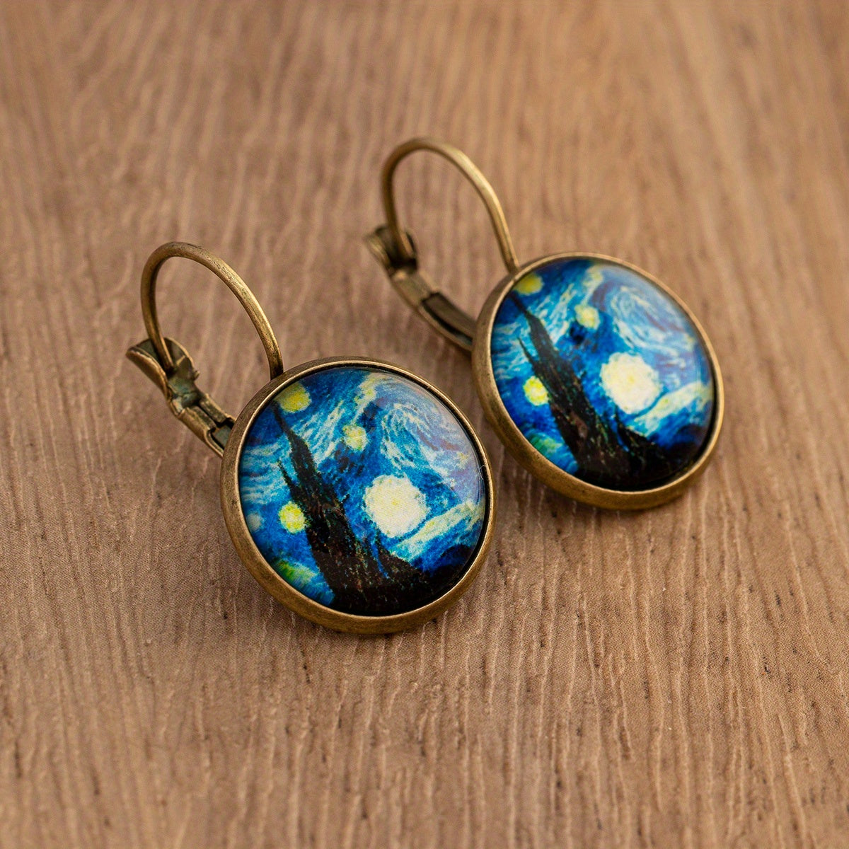 أقراط دائرية برسمة زيتية لريشة الطاووس وزهرة الهندباء